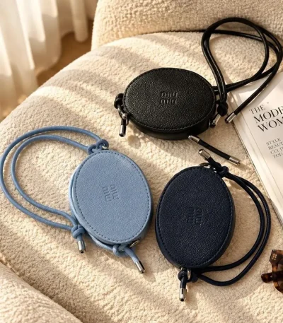Women's Miu Miu mini bag with adjustable strap available in black, navy blue, and blue